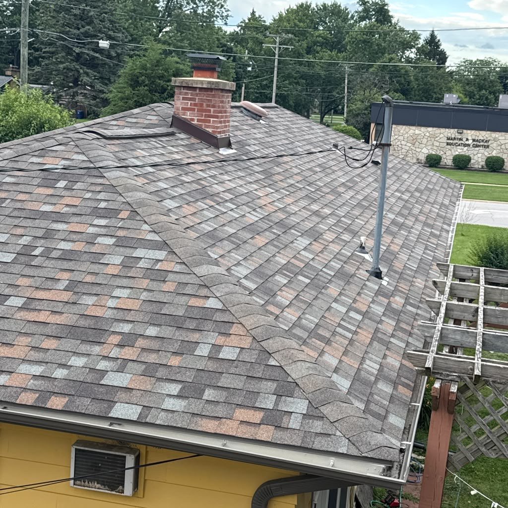 Close-up of new architectural roof shingles and chimney flashing